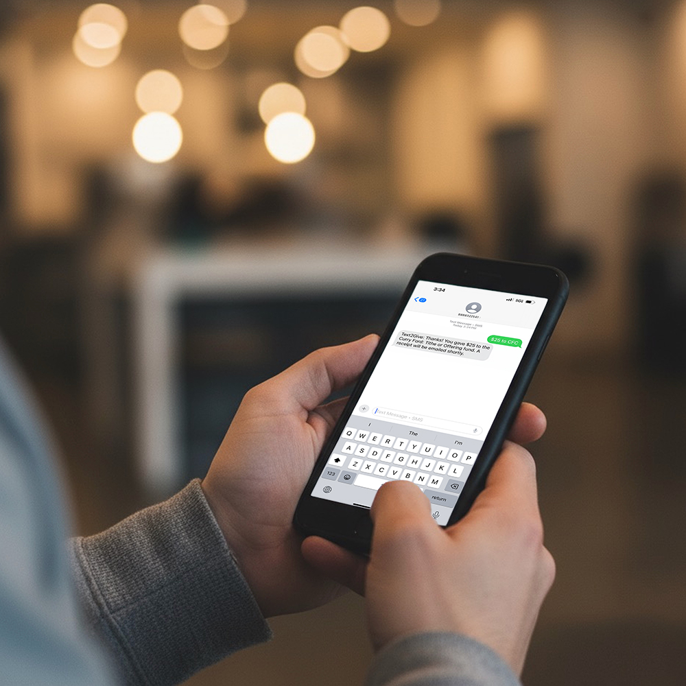 Person holding a phone with a text message for giving.