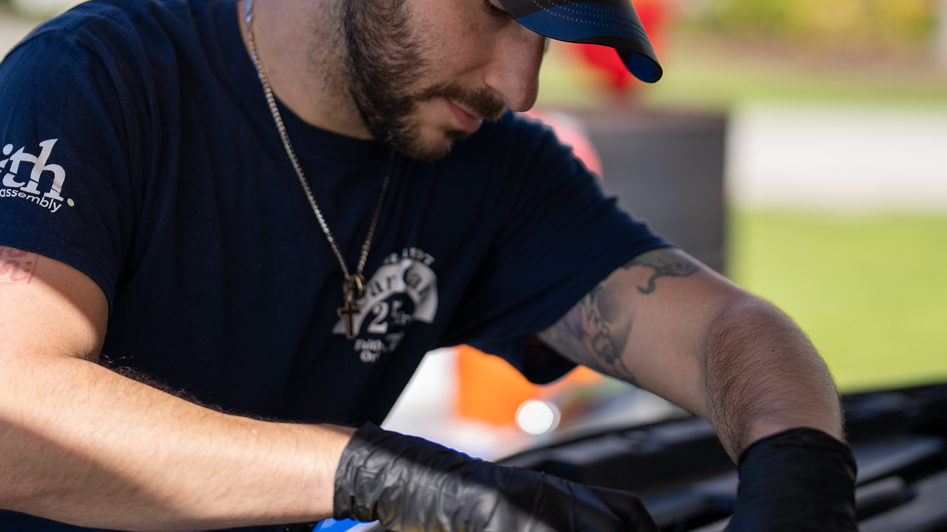 man looking into hood of car